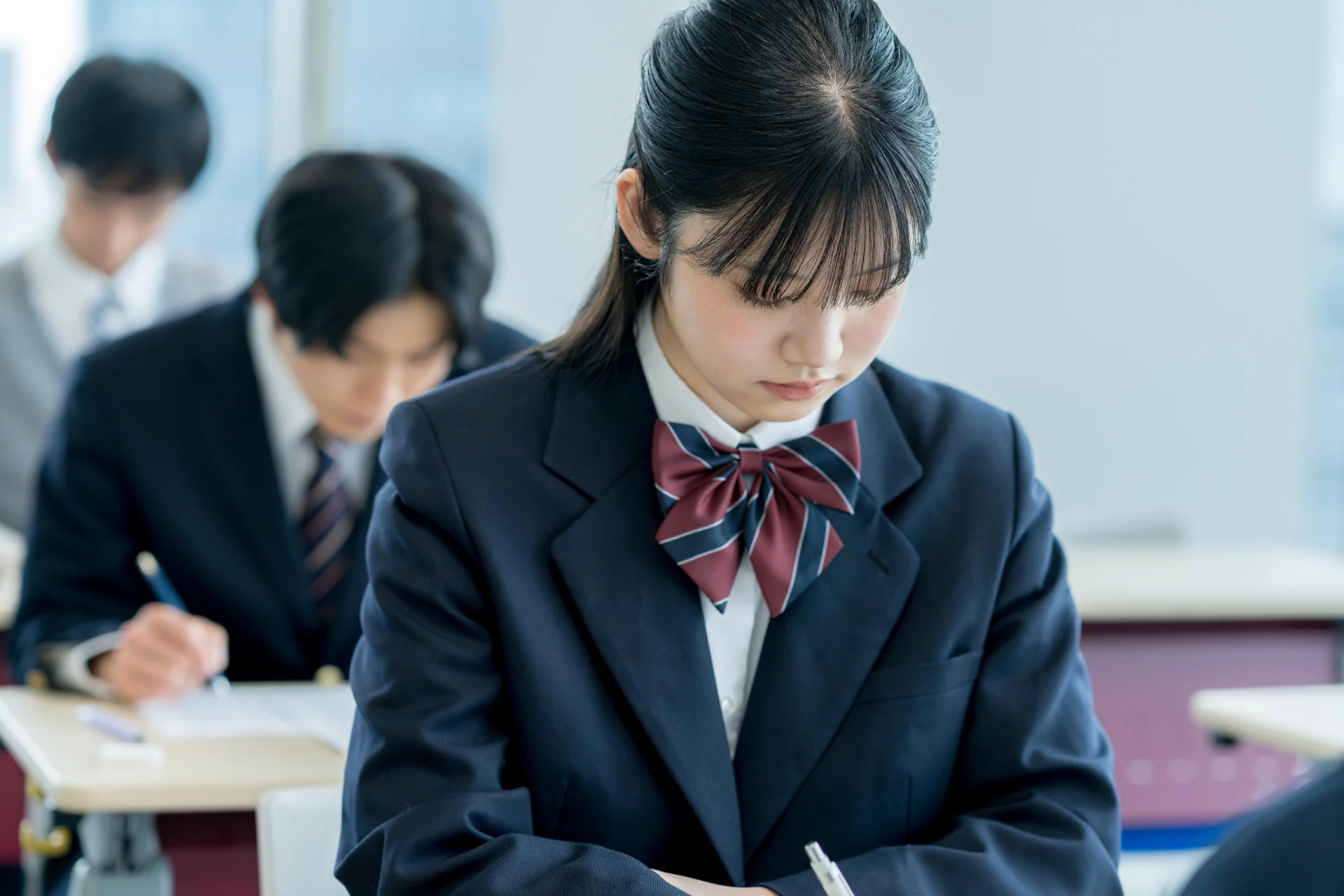 教室で問題演習に集中する現役高校生